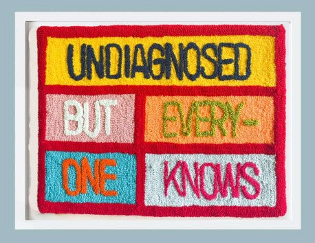 Embroidered textile with text 'undiagnosed but everyone knows' on a colourful background